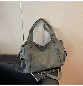 Macro detail of retro olive green tote bag showing matte texture and functional vertical zippers