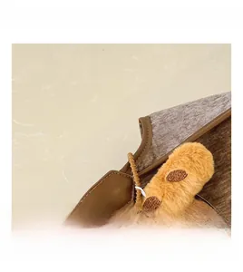Detail showing a dark brown faux leather bag with a cute yellow plush animal charm accessory