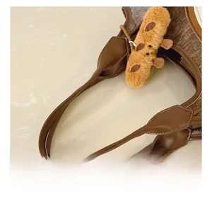 Detail of premium brown leather handles and textured fabric on a stylish tote bag