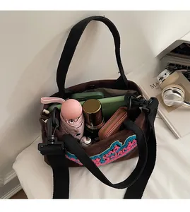 Vue intérieure d'un sac bandoulière marron montrant sa grande capacité pour accessoires