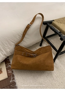 Detail of retro brown suede tote bag with leather straps on a woven rug