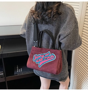 Détail du cabas bordeaux en faux daim avec broderie et bandoulière amovible noire