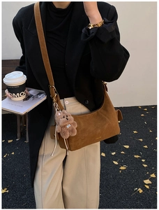Brown faux suede crescent bag detail with cute teddy bear charm and gold logo accent