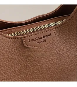 Macro shot of caramel brown lychee leather texture with gold zipper and embossed logo