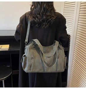 Modern grey-green tote bag showing large capacity on model in an indoor setting