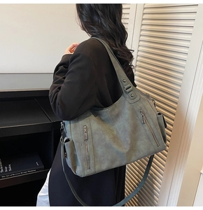 Sage green large tote bag side view with metallic zippers and wide shoulder strap