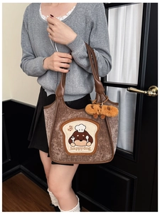 Detail of vintage brown corduroy tote bag featuring happy dog embroidery and plush bone charm