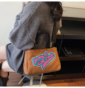 Détail du sac cabas en peluche marron avec broderie colorée et bandoulière réglable
