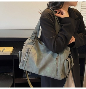 Detail view of large olive green tote bag featuring multiple pockets and soft texture