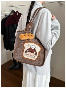 Detail of plush brown tote bag with cute dog embroidery and bread pendant accessory