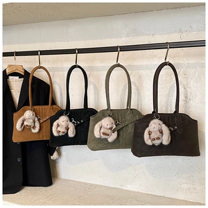 Row of four vintage suede tote bags in assorted colors with plush bunny charms