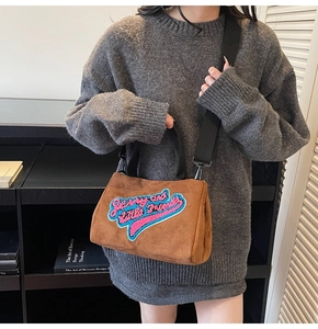 Détail du sac à main en daim marron pelucheux avec broderie colorée et bandoulière large