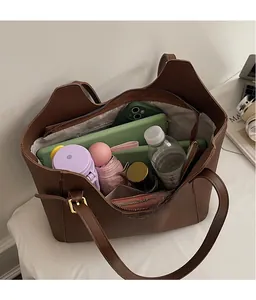 Detail view of large capacity brown tote bag interior with multiple everyday items