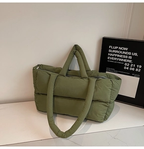 Detailed view of olive green quilted puffer tote bag with dual handles and zipper closure