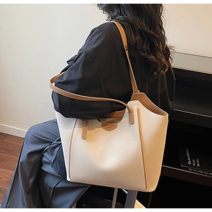 Detail of off-white tote bag with lychee texture and contrast caramel leather straps