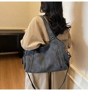 Dark grey large matte leather tote bag with metallic zipper detail and wide top handles