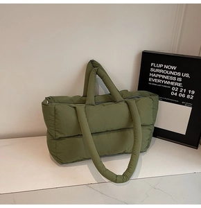 Detailed view of olive green quilted puffer tote bag with dual straps and soft texture