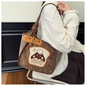 Detail of brown corduroy tote bag with cute dog embroidery and plush bread charm