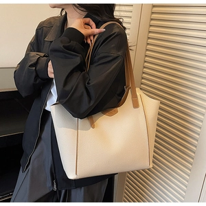 Detailed macro of beige lychee leather tote bag with brown contrast trim and handles