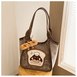 Detail of dark brown corduroy tote bag with dog embroidery and plush keychain