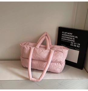 Detailed view of pink quilted tote bag showing padded texture and dual handle design