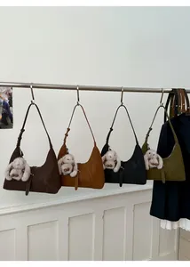 Detail view of suede crescent handbags in four colors with cute bunny charms