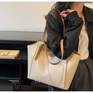Detailed view of cream leather tote bag interior with inner zipper and fashion label