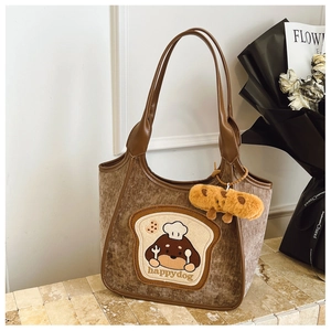 Detail of plush tote bag with cute happy dog toast embroidery and bread charm