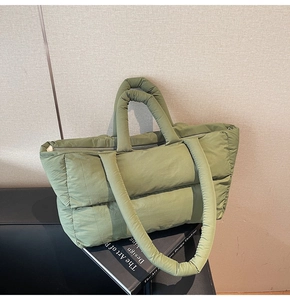 Macro shot of olive green quilted puffer tote bag with thick padded strap and nylon finish