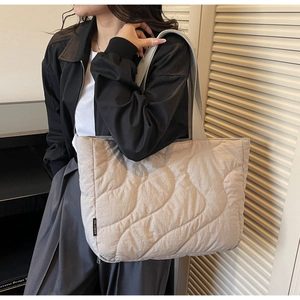 Detailed side view of a large quilted tote bag with wave stitching for daily commute