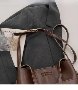 Detail of dark brown leather tote bag with Fashion & bag print and adjustable strap