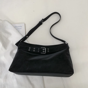Close-up of black suede tote bag featuring vintage silver buckle and eyelet belt details