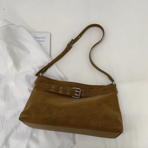 Close-up of vintage brown suede tote bag with metal buckle and adjustable strap