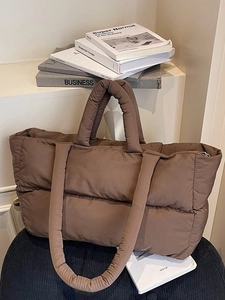 Deep brown quilted puffer tote bag with top handles and shoulder strap for daily commuting
