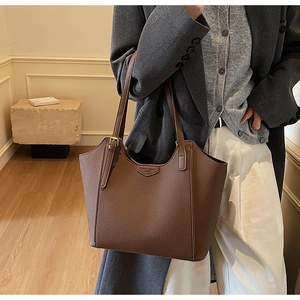 Detailed view of the dark brown lychee textured leather tote bag with fashion metal logo