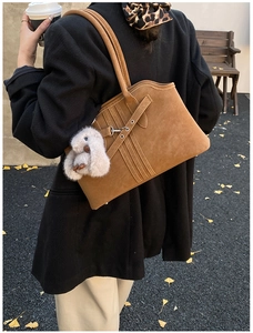 Sac fourre-tout en daim marron avec sangles et breloque lapin dans un décor d'automne