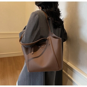 Detail of a brown leather tote bag with Fashion trend label and smooth metal zipper