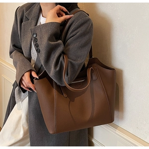 Detailed view of the brown leather tote bag interior with zipper pocket and dual handles