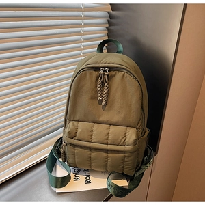 Detail of olive green quilted backpack with soft down-like texture and woven zipper puller