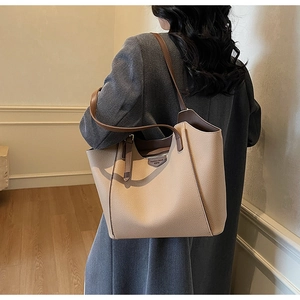 Detail of the large beige tote bag interior featuring a zipper pocket and smooth leather strap