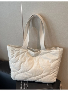 Minimalist beige quilted tote bag with wave stitching and wide shoulder straps for women