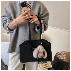 Detail view of black velvet tote bag with vertical stripes and a cute bunny charm