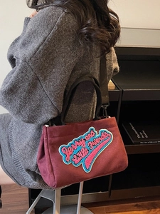 Sac bandoulière en peluche bordeaux avec broderie et anses tissées noires