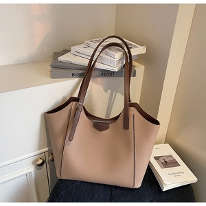 Detail of beige lychee grain leather tote bag with dark brown straps and metal zipper