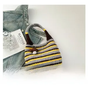 Detail of the knit bag showing multi-color striped patterns and mushroom charm