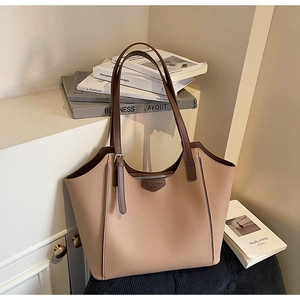 Detail of minimalist leather tote bag with brown straps and fashion trend emblem