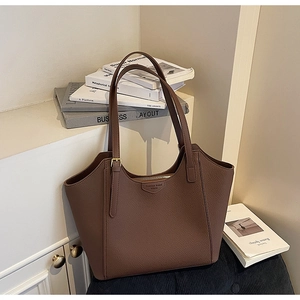 Close-up of dark brown lychee leather tote bag featuring metal buckle and zipper detail