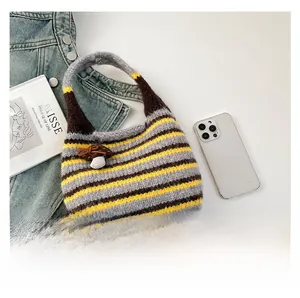 Detailed knit texture of a colorful striped bucket bag with a cute mushroom charm accessory
