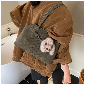 Retro dark green tote bag in faux suede featuring crisscross straps and rabbit charm