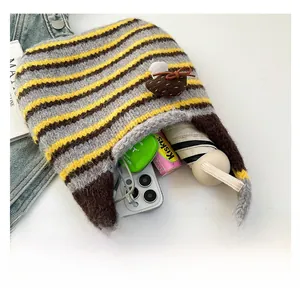 Interior view of striped knit shoulder bag showing capacity for phone and umbrella